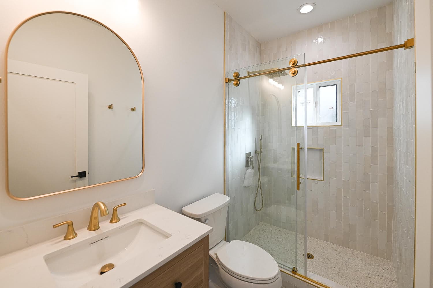 Luxury master bathroom renovation with marble tile and frameless glass shower by Navarro's Custom Homes & ADUs